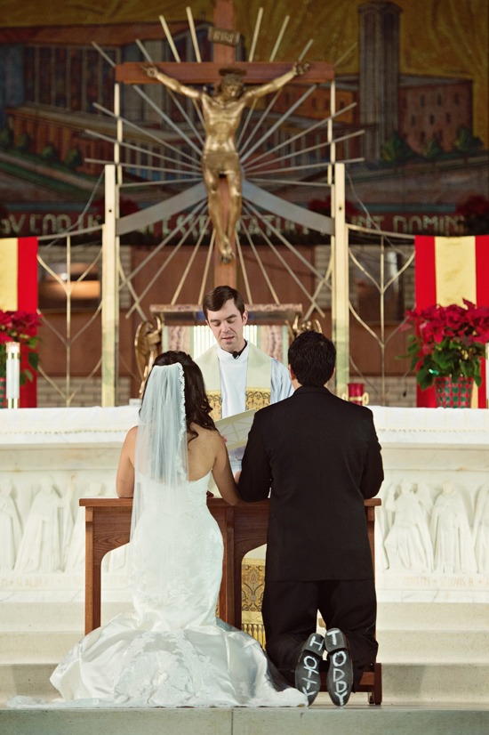 Bride and groom kneel for wedding ceremony in church