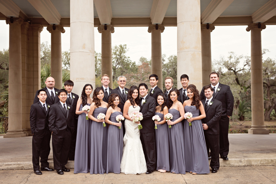 Wedding party poses under grand columns with bride