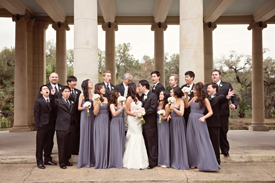 Bride and groom kissing with funny wedding party group