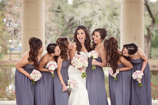 Bride and bridesmaids laughing with bouquets outside