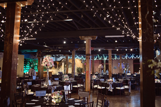 Event venue decorated with string lights and floral centerpieces