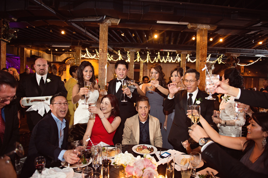 Wedding guests toasting champagne at reception table