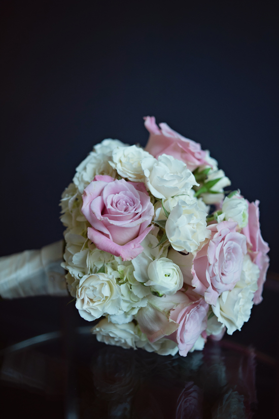 Elegant bridal bouquet of pink and white roses on a dark surface