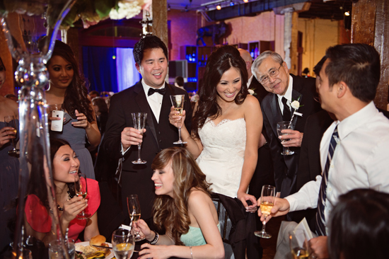 Joyful wedding guests toasting with champagne glasses