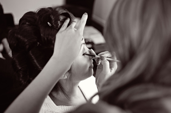 Bride getting eye makeup applied in black and white