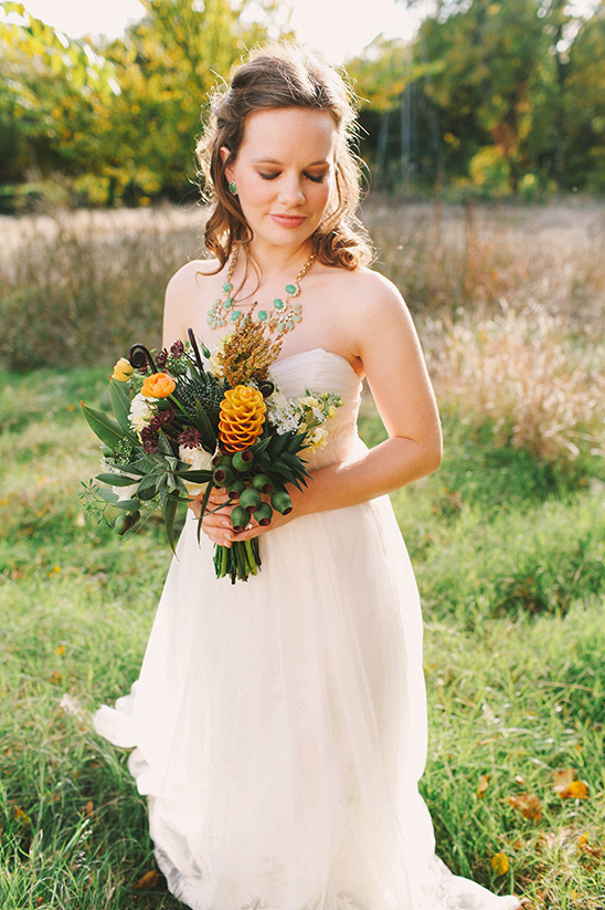 Bride in a white dress holding bouquet outdoors