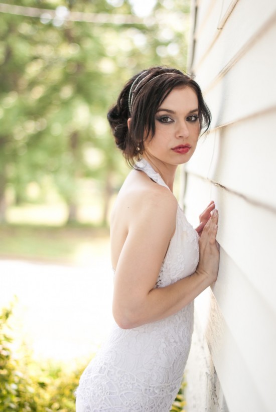 Brunette bride in white lace dress poses outdoors