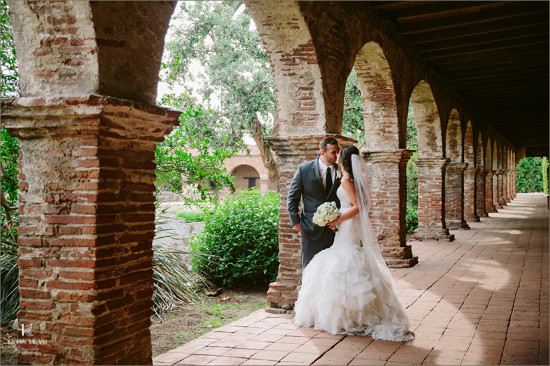 Romantic wedding couple under brick archway