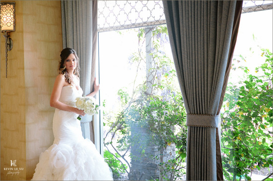 Bride in white wedding dress window portrait