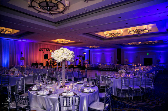 Luxury wedding reception venue with floral decor and blue lights