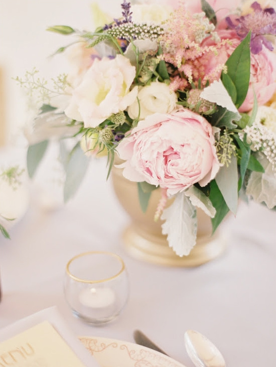 Soft pastel wedding flowers in elegant gold vase
