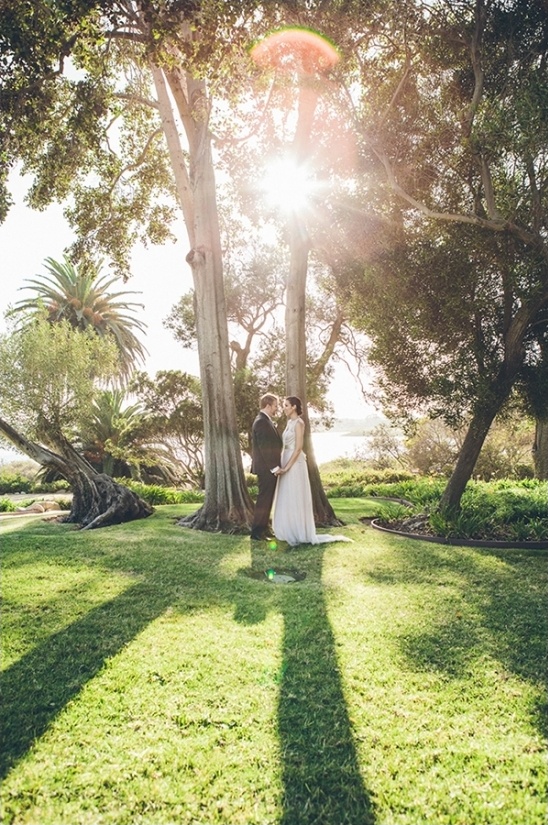 Wedding couple in a garden with sunlight filtering trees