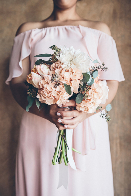 Elegant woman holds beautiful peach and white bouquet