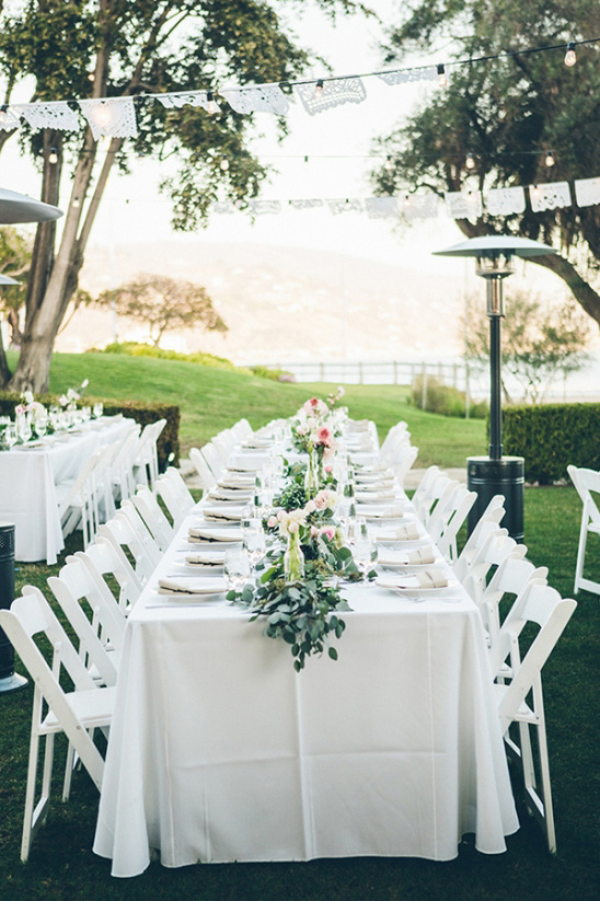 Wedding reception table flowers white chairs outdoors