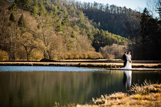 A couple marries on a dock by a lake in the mountains