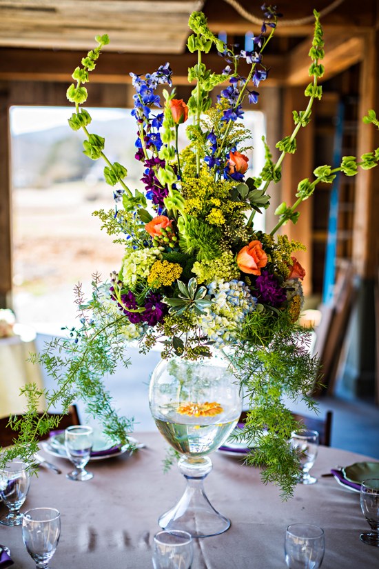 Tall vibrant floral centerpiece in glass vase
