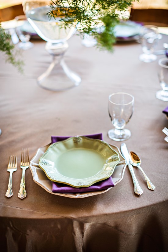 Elegant table setting with green plate and purple napkin