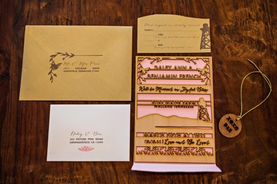 Unique laser cut wedding invitation suite on wood background