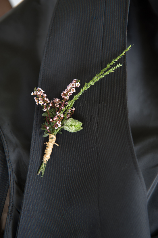 Grooms rustic floral boutonniere on a dark suit lapel