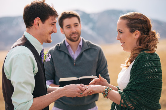 Happy couple exchange rings at outdoor wedding ceremony