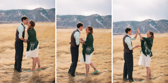 Happy wedding couple kiss and high five mountains view