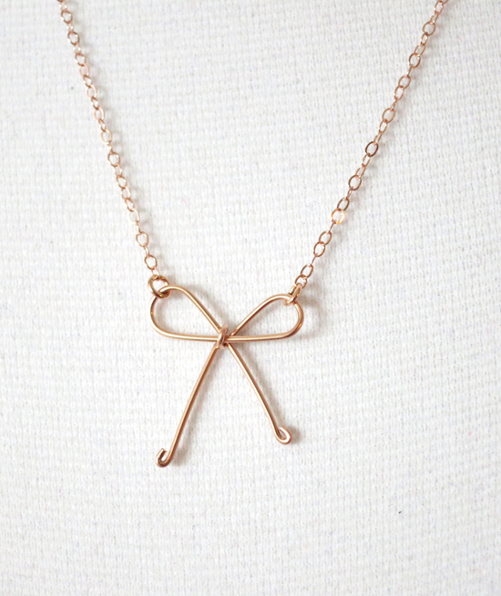 Delicate rose gold necklace with a wire bow pendant