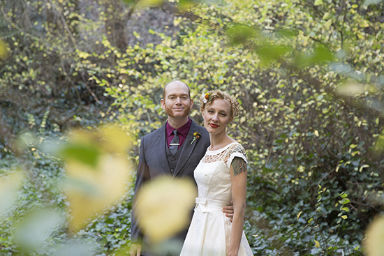 Happy couple posing for wedding photo in autumnal foliage