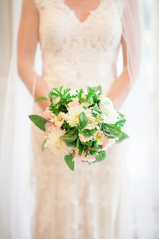 Bride in lace dress holding a floral wedding bouquet