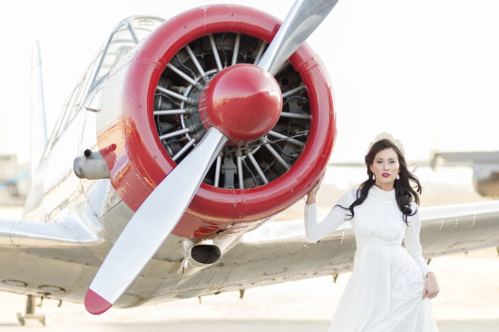 Woman in white dress with vintage airplane