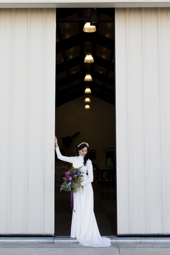 Bride in white dress holds flower bouquet at wedding venue