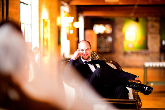 Happy groom relaxing in ornate chair on his wedding day
