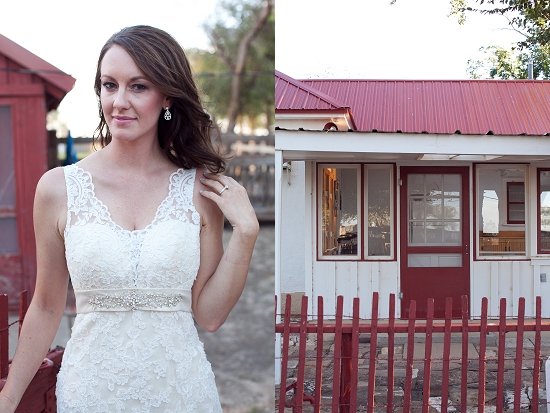 Bride in lace gown near a building, red accents and rustic charm