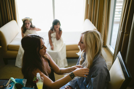 Bride getting ready with bridesmaids in a hotel room before the wedding