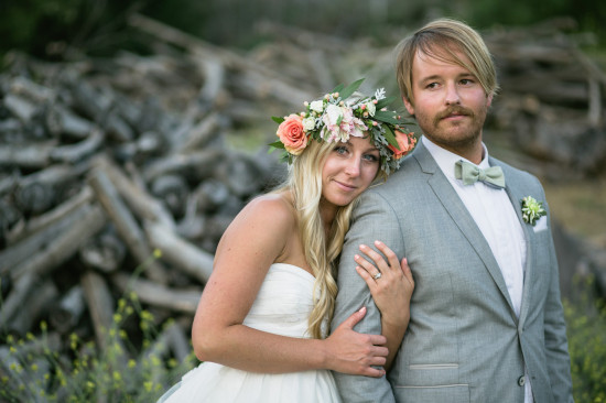 Bride and groom embrace on wedding day, flower crown and suit