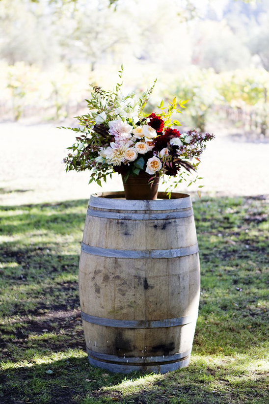 wine barrels and floral pieces used for ceremony backdrop