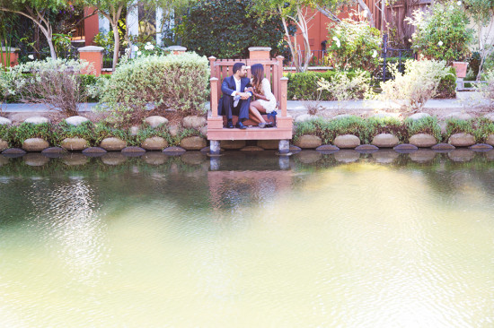 Couple sits on a dock overlooking the water at a park