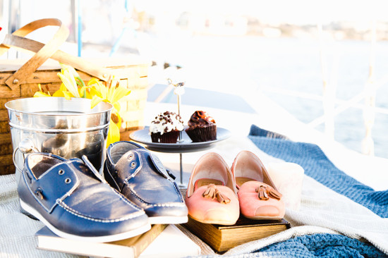 Shoes and cupcakes on a blanket by the sea for a picnic