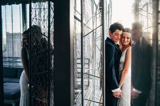 Wedding couple embracing, reflected, near wire structure