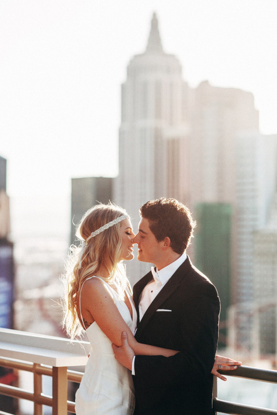 Romantic wedding couple share a kiss on a sunny rooftop