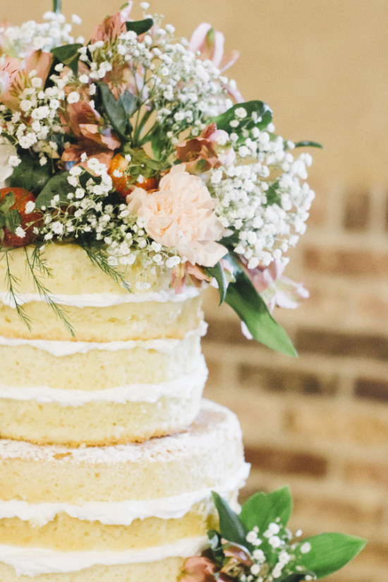 Beautiful naked wedding cake crowned with fresh flowers