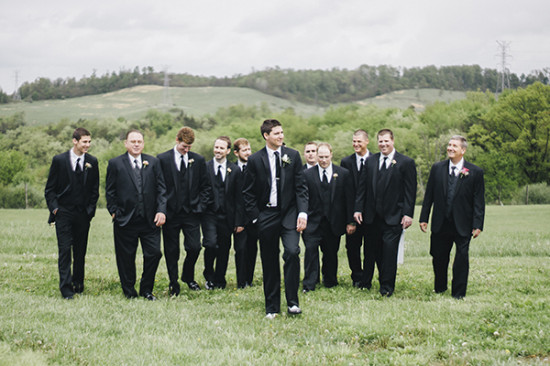 Groom and groomsmen in black suits outdoor wedding