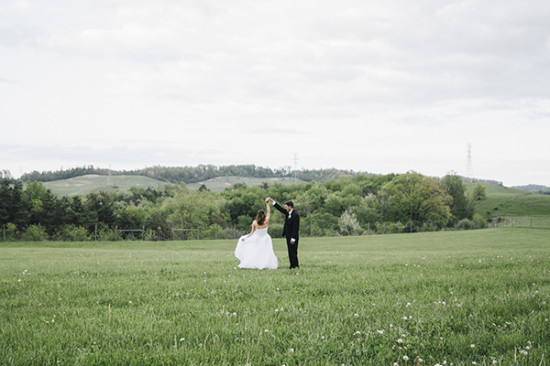 Bride and groom dance in a grassy field