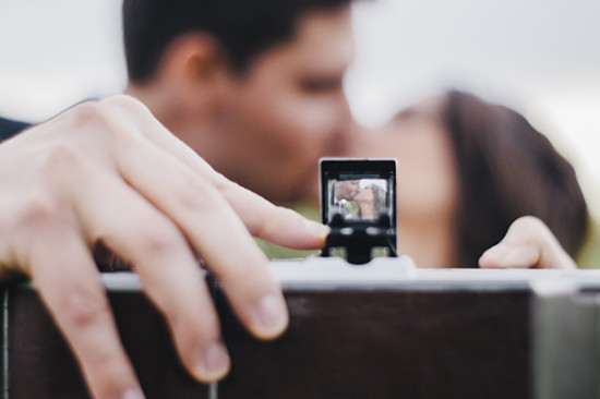 Kissing couple seen through vintage camera viewfinder
