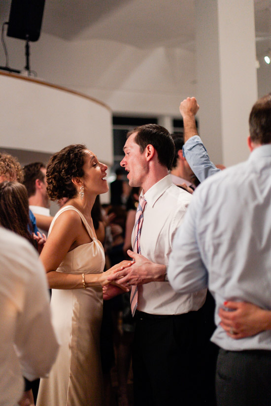Bride and groom dancing at wedding reception with joyful expressions