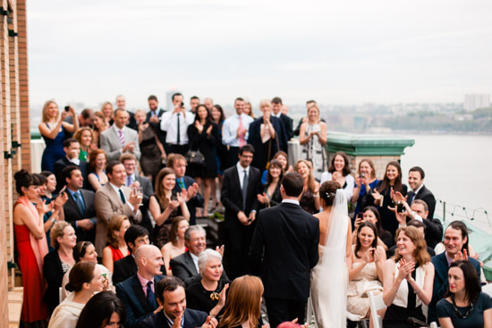 Wedding ceremony with bride and groom, guests clapping in celebration