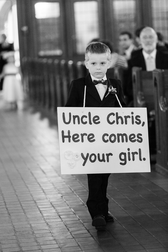 Ring bearer carries a sign Here comes your girl in a wedding