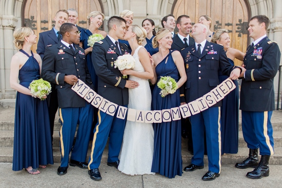Wedding party celebrates marriage with a Mission Accomplished banner