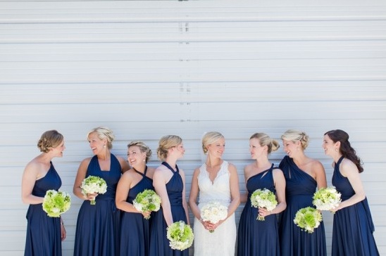 Bride with bridesmaids smiling in navy blue dresses