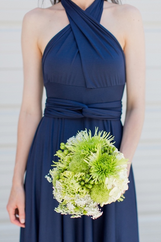 Navy blue bridesmaid dress with a vibrant green bouquet