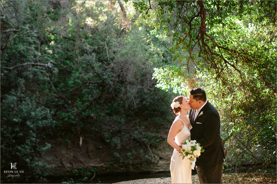 Newlyweds share a tender kiss in a beautiful outdoor wedding ceremony
